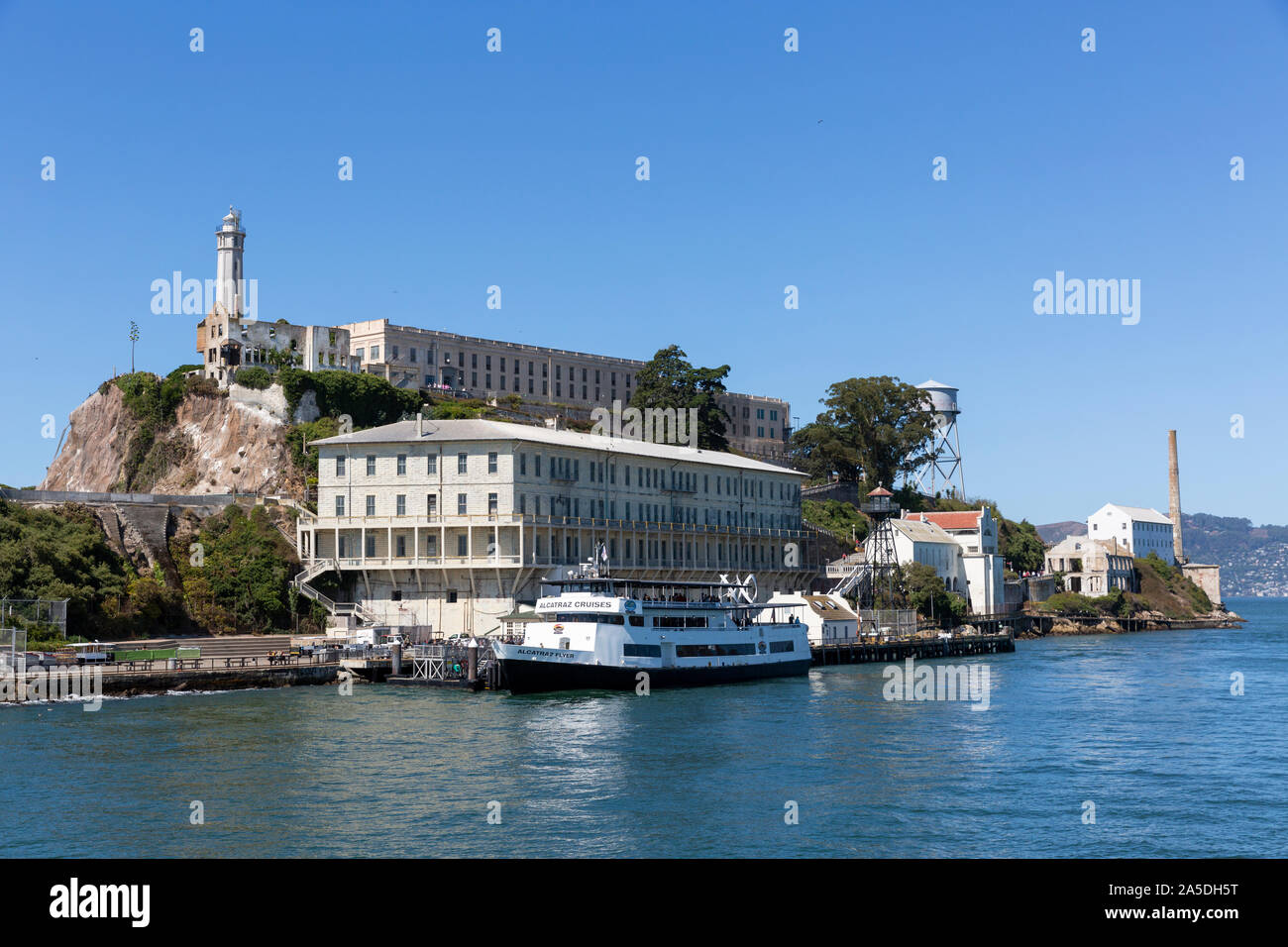 SAN FRANCISCO, USA - SEPTEMBER 8, 2019 : Wide view of Alcatraz Island and prison with an Alcatraz Cruise boat moored at the dock. Stock Photo