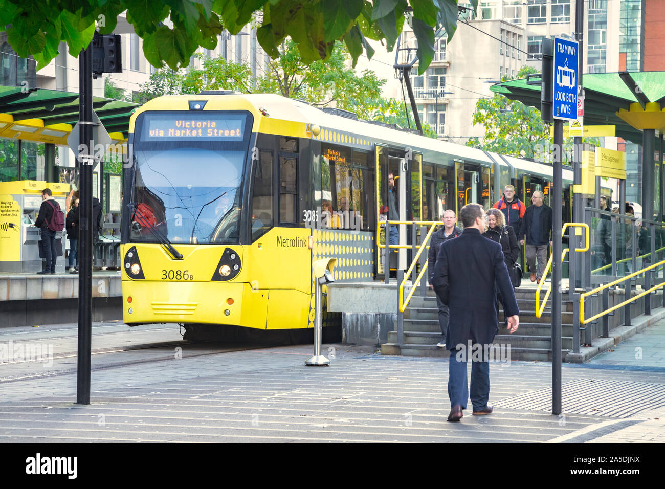 2 November 2018: Manchester, UK - Metrolink tram at tram stop in St Peter's Square in the CBD, people getting on and off. Stock Photo