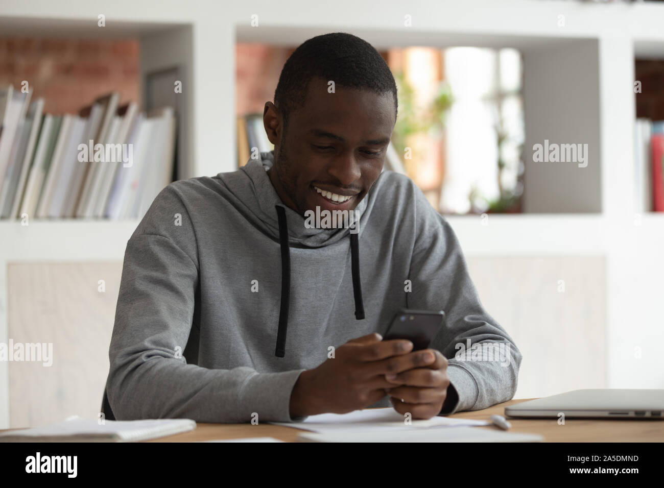 African man holds smartphone looks at screen read media news Stock Photo