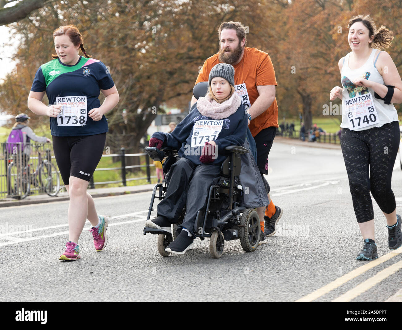 Runners and wheelchair in the Cambridge Town and Gown 10k run Oct 2019 scenic run passing landmarks, historic University Colleges and along river cam Stock Photo