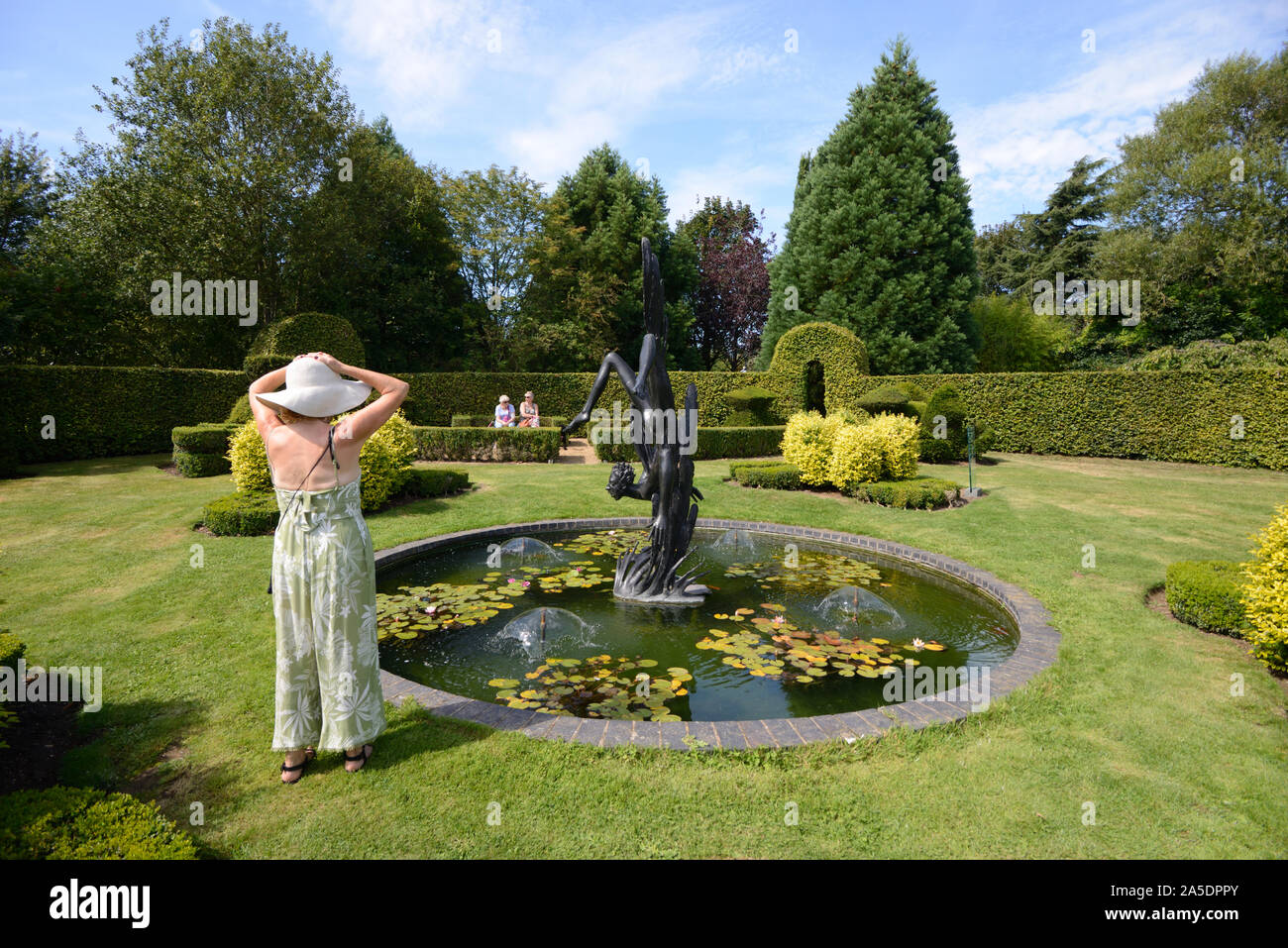 Visitors or Tourists Admire the Round Ornamental Pond & Statue of