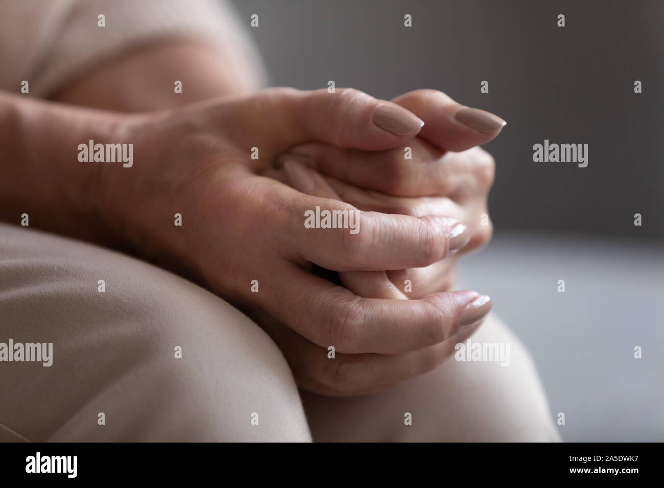 Close up view of older senior female hands clasped Stock Photo
