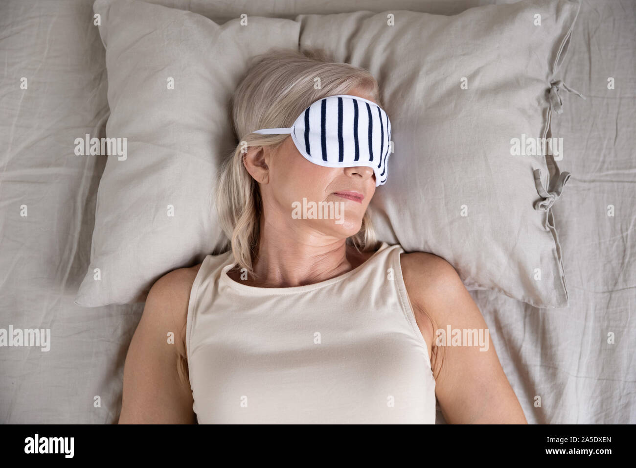Calm old woman enjoying sleep wear sleeping mask in bed Stock Photo Alamy