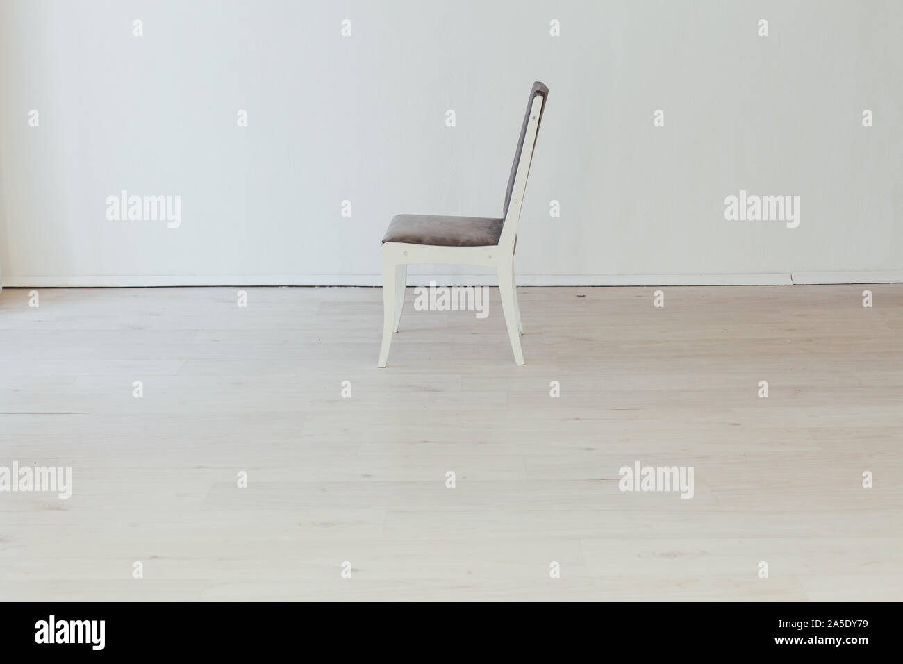 gray chair in the interior of an empty white room Stock Photo