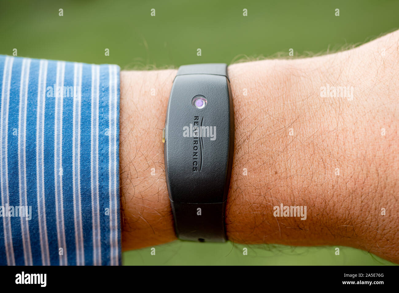 A man in a shirt wearing a Philips Respironics Actiwatch, a clinical