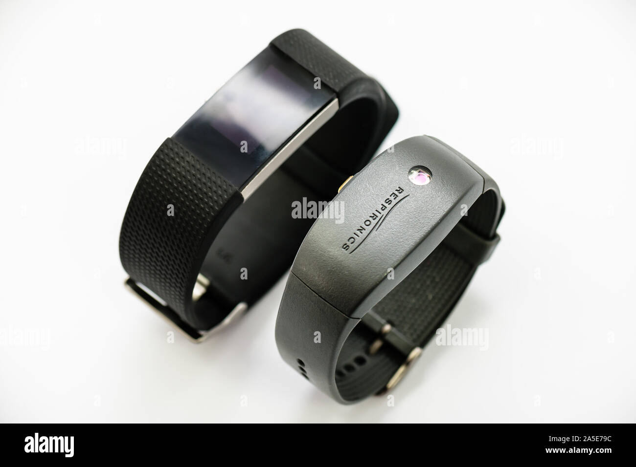 A Philips Respironics Actiwatch and a Fitbit Charge 2. Clinical vs commercial activity tracker watch for insomnia, sleep studies and monitoring. Stock Photo