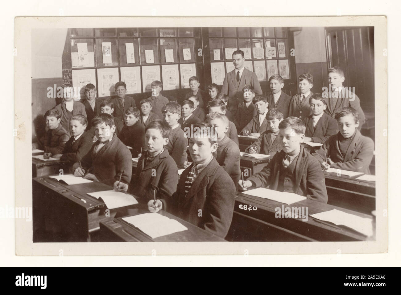 Early 1900's postcard of 1920's schoolboys in classroom, circa 1920's U.K. Stock Photo