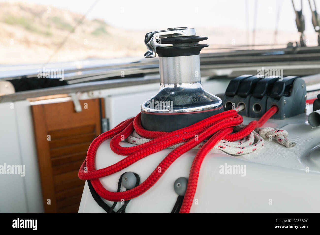 Sailing yacht equipment, sailbot winch with red rope close-up photo Stock Photo