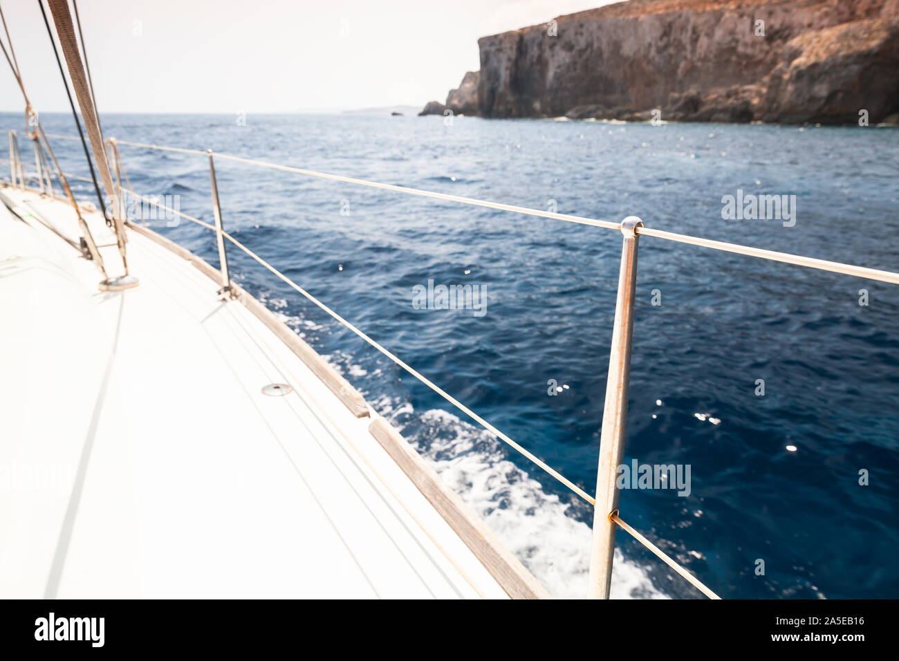 White sailing yacht deck with railings and ropes. Boat trip at sunny ...