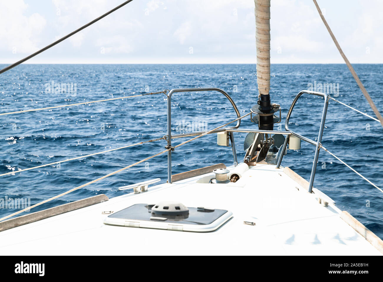 White yacht bow with rolled jib sail and anchor Stock Photo Alamy