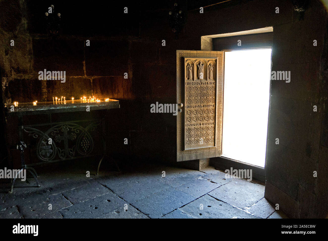 Armenia, Saint Hripsime Church: ornately carved wooden door with sacrificial candles Stock Photo