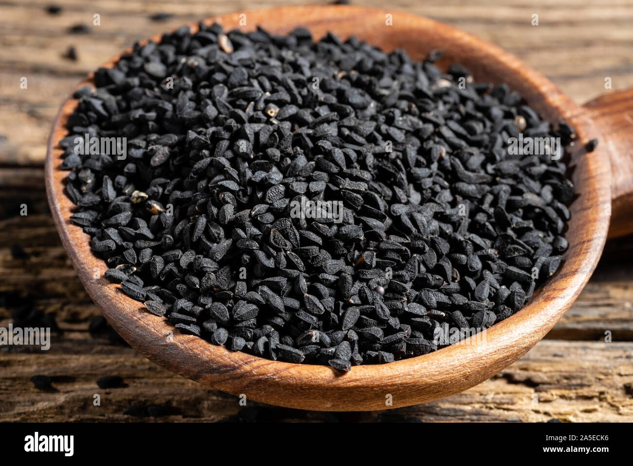 Black cumin seeds on a wooden spoon Stock Photo