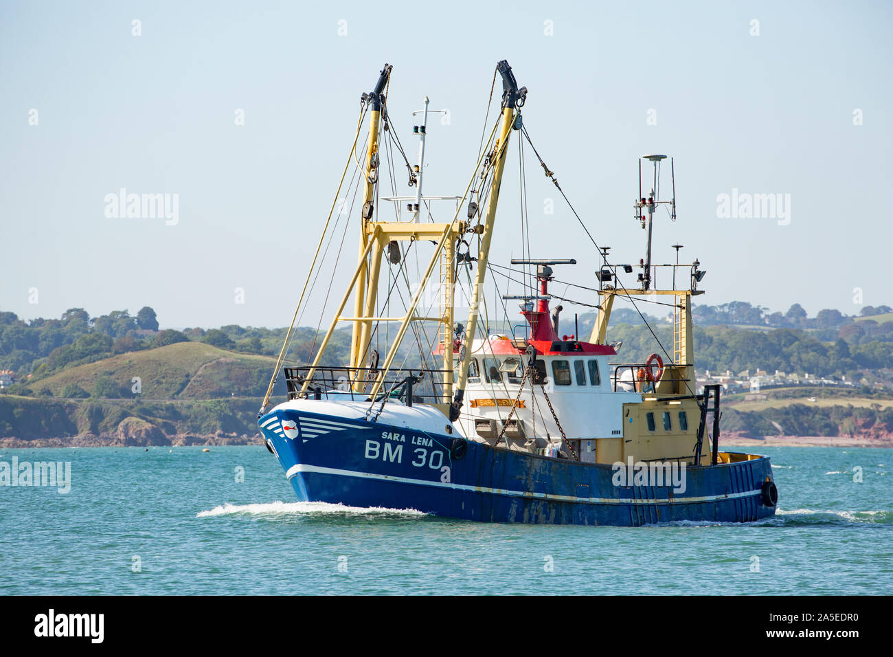 A fishing boat entering the outer harbour of Brixham Port in the Autumn. Brixham is home to a large fishing fleet and fish market. Devon England UK GB Stock Photo