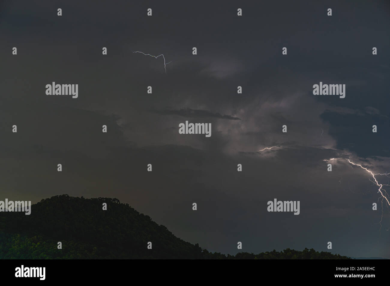 The Storm lightning strikes in mountains during a thunderstorm at night. Beautiful dramatic view Stock Photo
