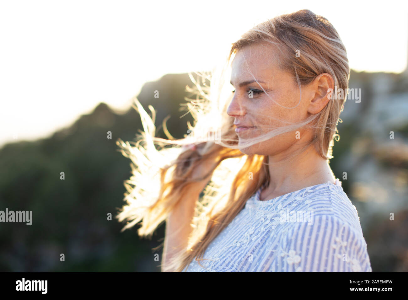 Young 20s blonde woman looking away profile view in nature Stock Photo