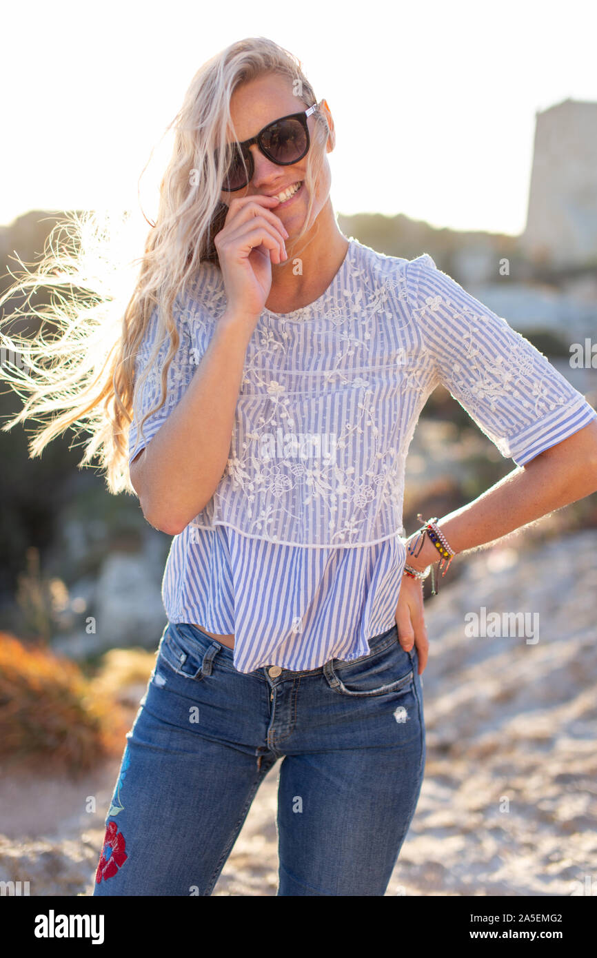 Happy natural blonde woman in sunglasses posing outdoors Stock Photo