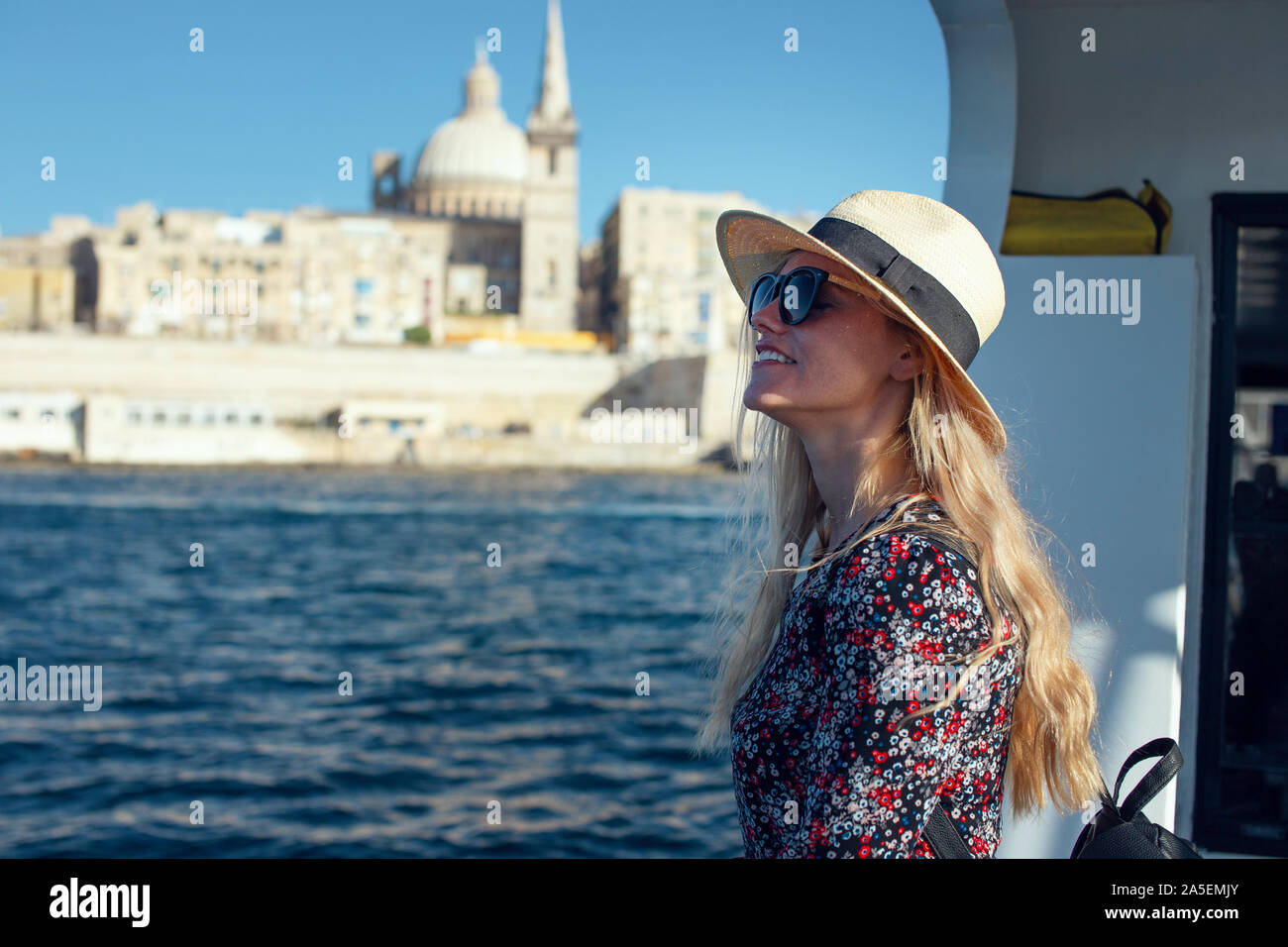 Excited young Mediterranean blonde woman arriving to Valletta, Malta Stock Photo