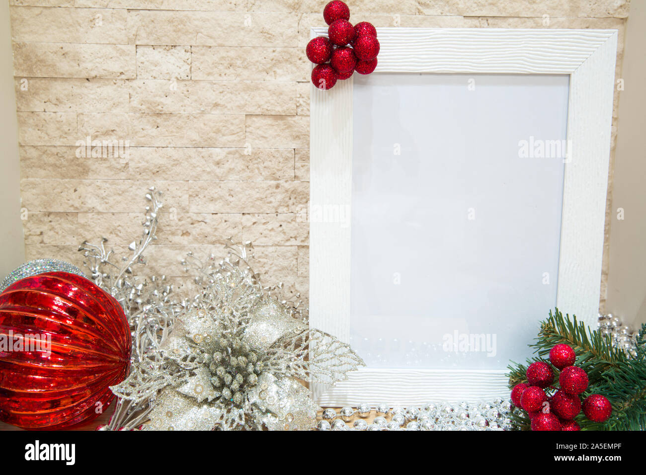 Red berries with fir tree branches, silver and red Christms decoration. Mock up, free space for text. Beautiful white frame. Stock Photo