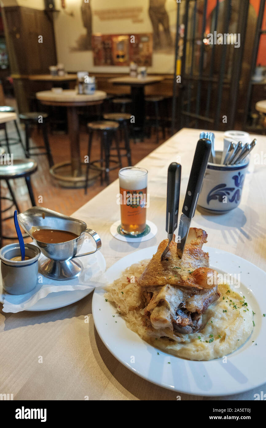 roasted pork knuckle with Sauerkraut and mashed potatoes and full glass ...
