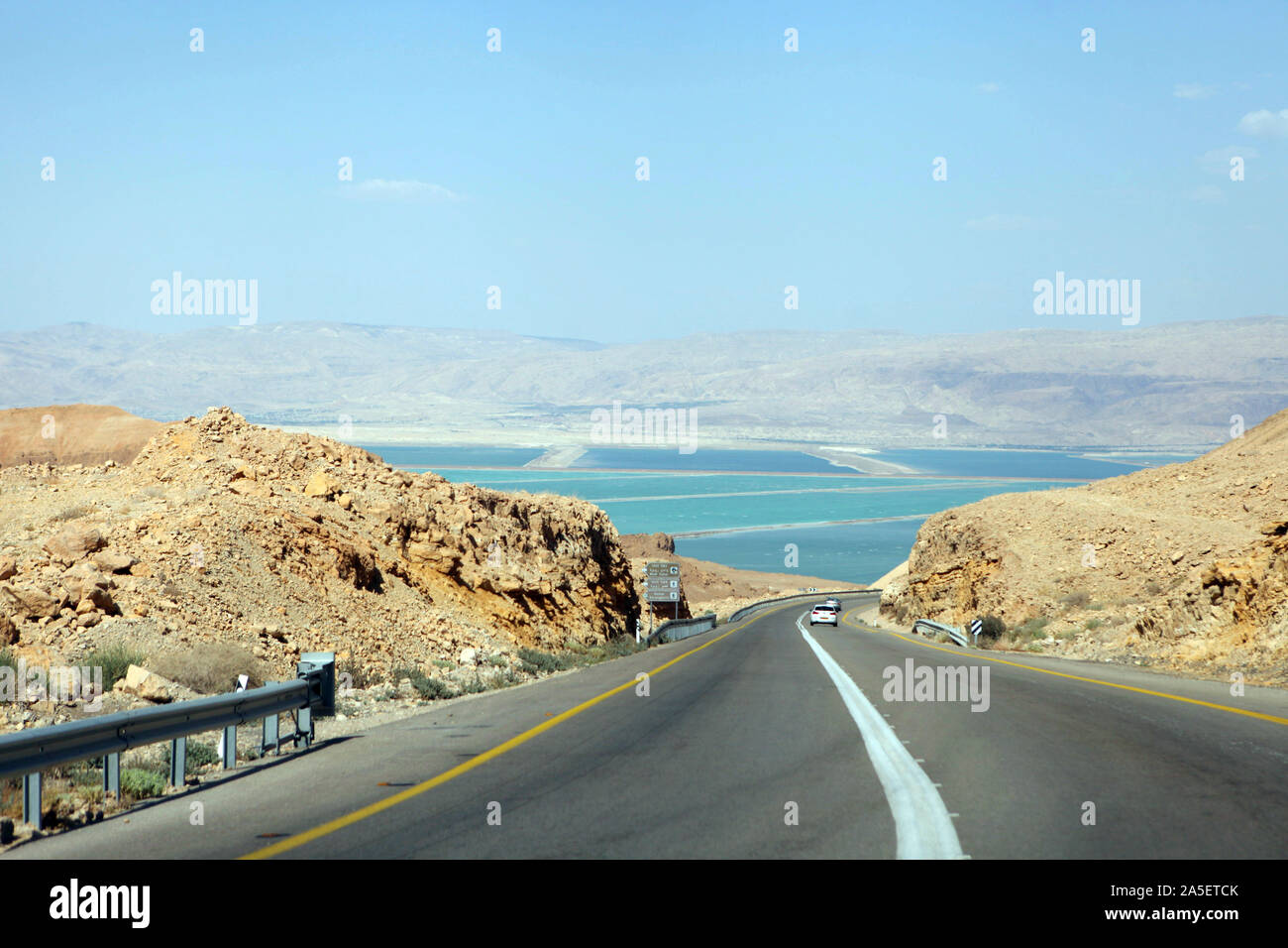 Deadseaview on a curvy sandy road on a highway that runs along the Dead Sea from one side and Edom Mountains at Arava Desert from the other in Israel. Stock Photo