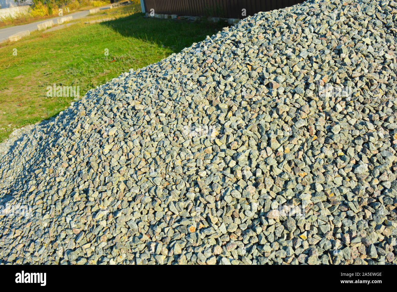 Building materials for construction and repair work, clean fine gravel rubble, a pile of building pebbles in the autumn sunlight. Stock Photo