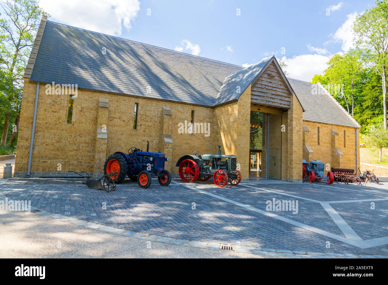 Vintage tractors and farm machinery outside the threshing barn at the newly restored 'The Newt in Somerset' garden and hotel, nr Bruton, England,UK Stock Photo