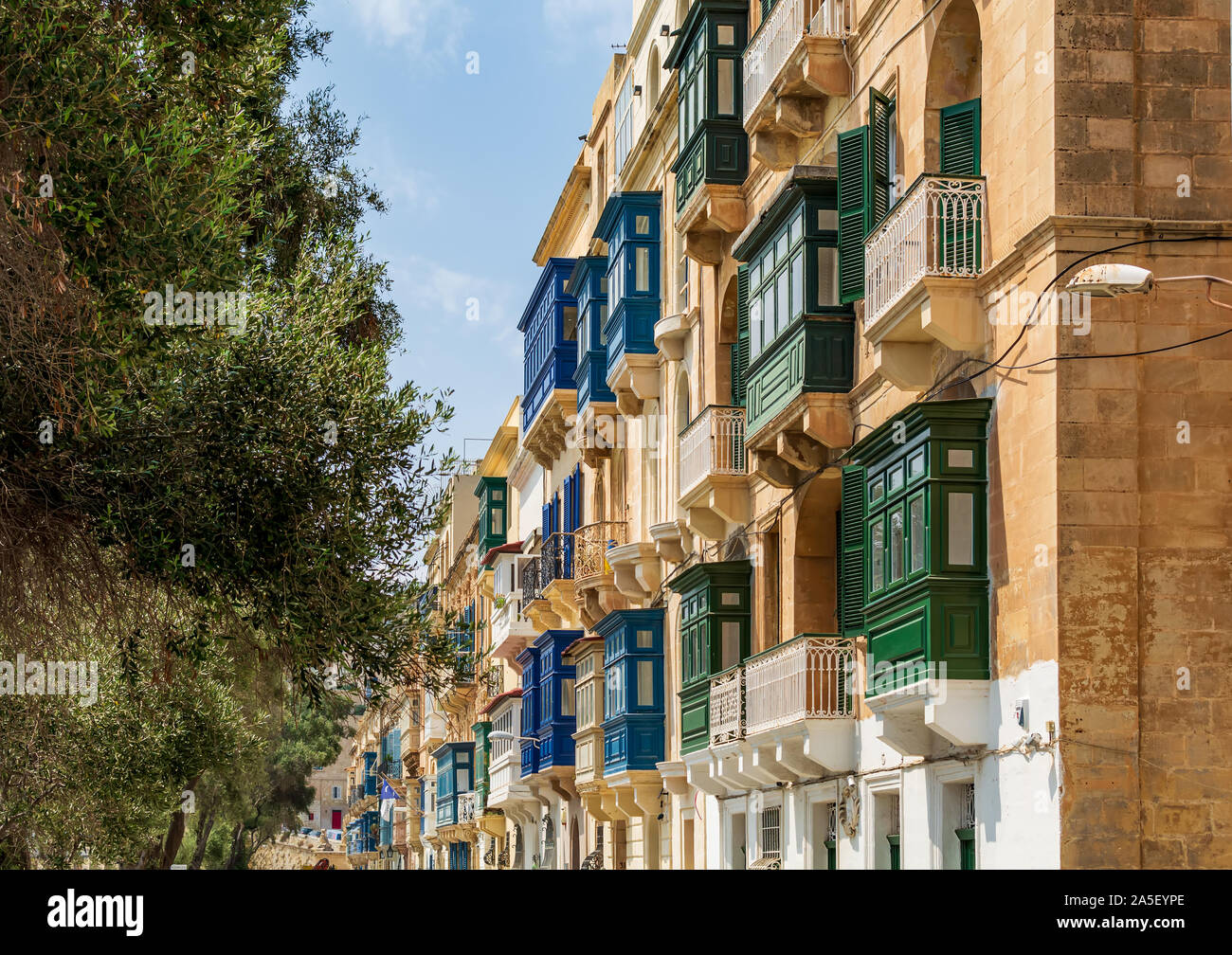 Residential house facade with traditional Maltese multicolored enclosed wooden balconies in Valletta, Malta, in summer day. Stock Photo