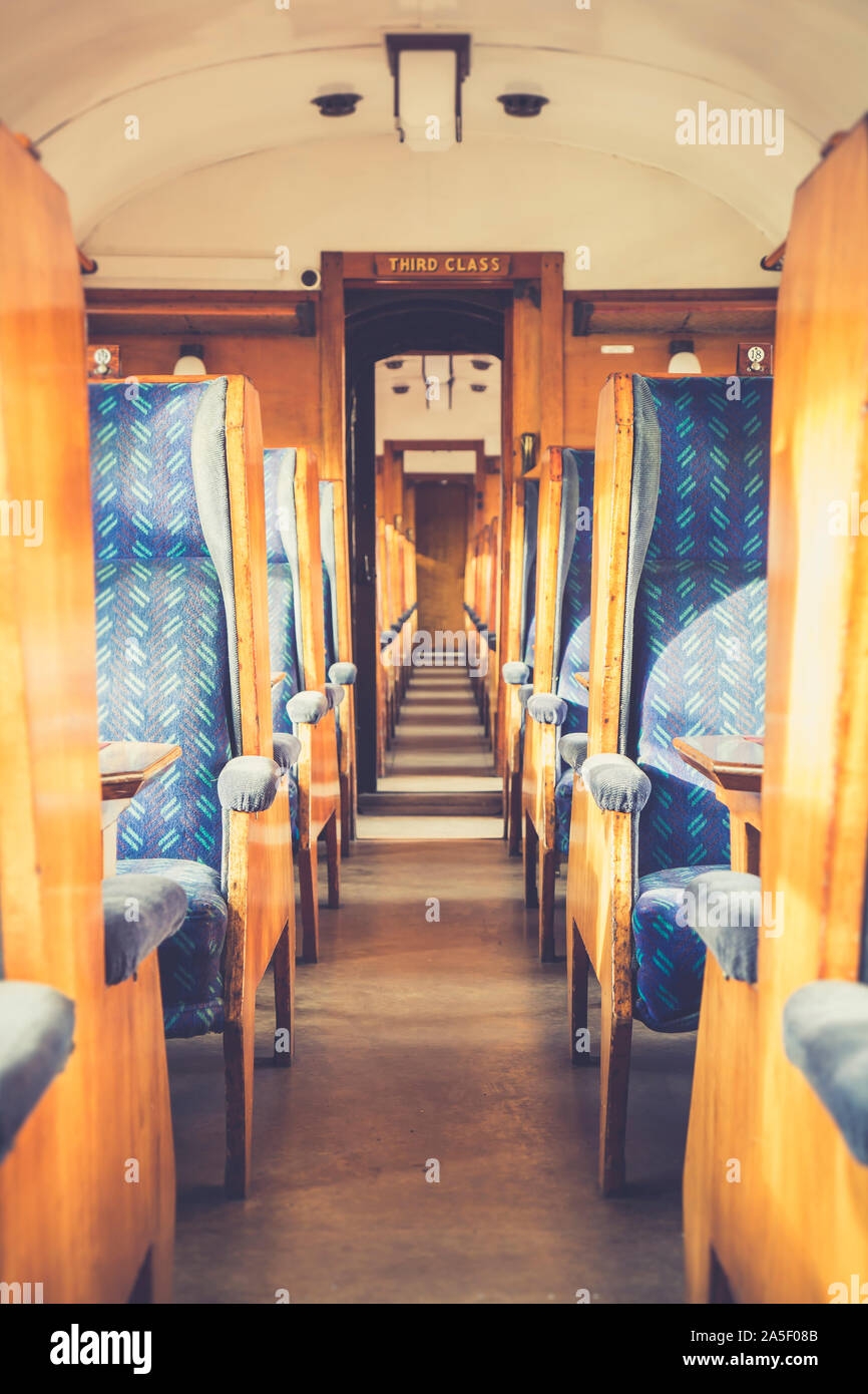 Artistic interior view of empty vintage railway carriage, UK lit by autumn sunshine. Vintage third class rail travel on Severn Valley heritage railway. Stock Photo