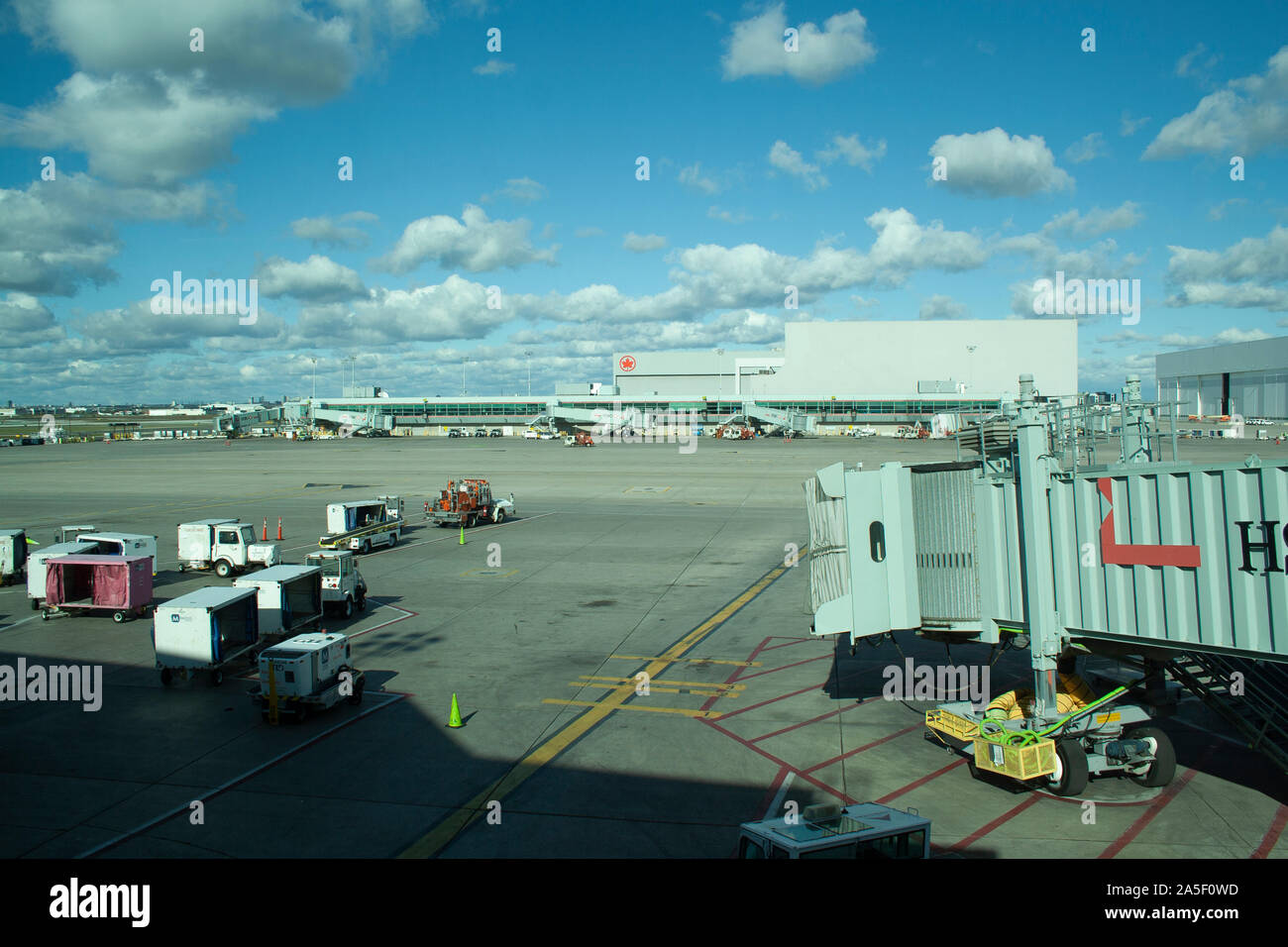 October 14, 2019 - Toronto, Ontario Canada- Looking out to the loading area of a terminal at Pearson Airport in Canada with luggage loading and gates Stock Photo