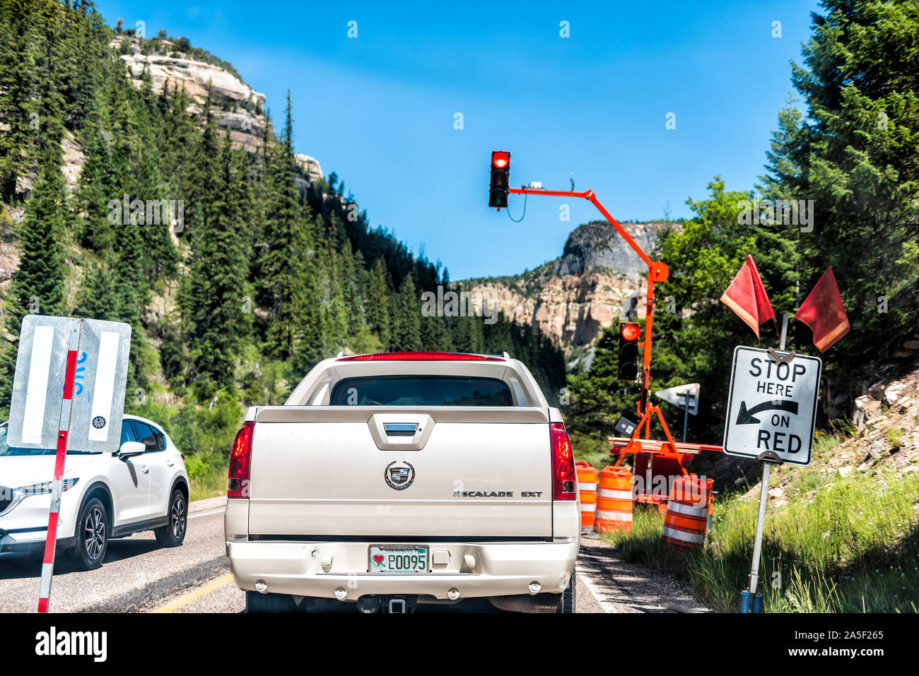 Duck Creek Village, USA - August 5, 2019: Cars in traffic on road in Dixie National Forest in Utah with construction and stoplight on scenic byway hig Stock Photo