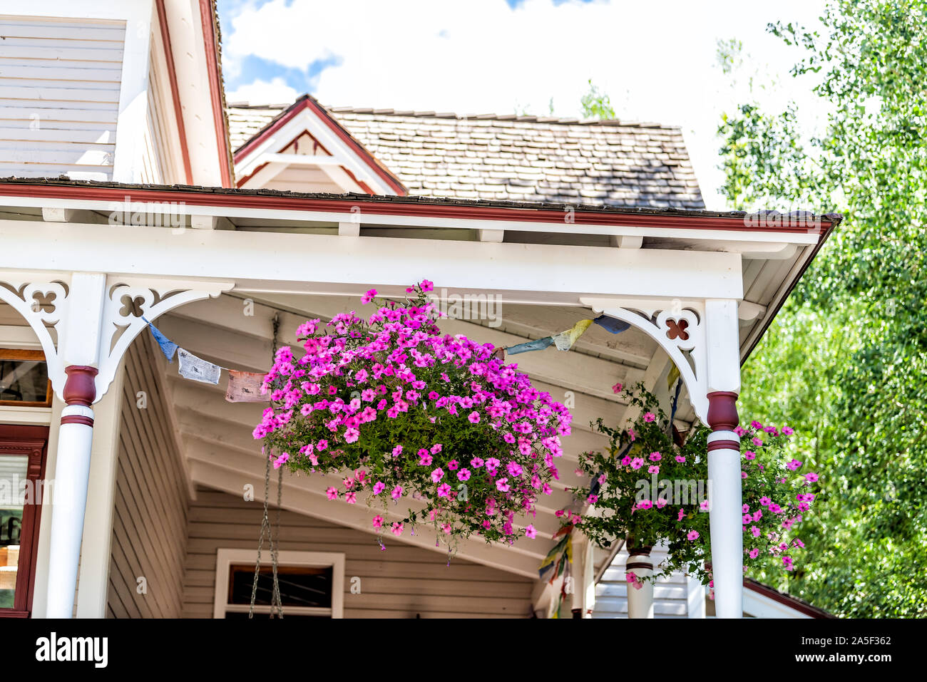 Ski resort town house with old beautiful architecture and front porch of generic typical building exterior closeup of pink flower decorations in Tellu Stock Photo