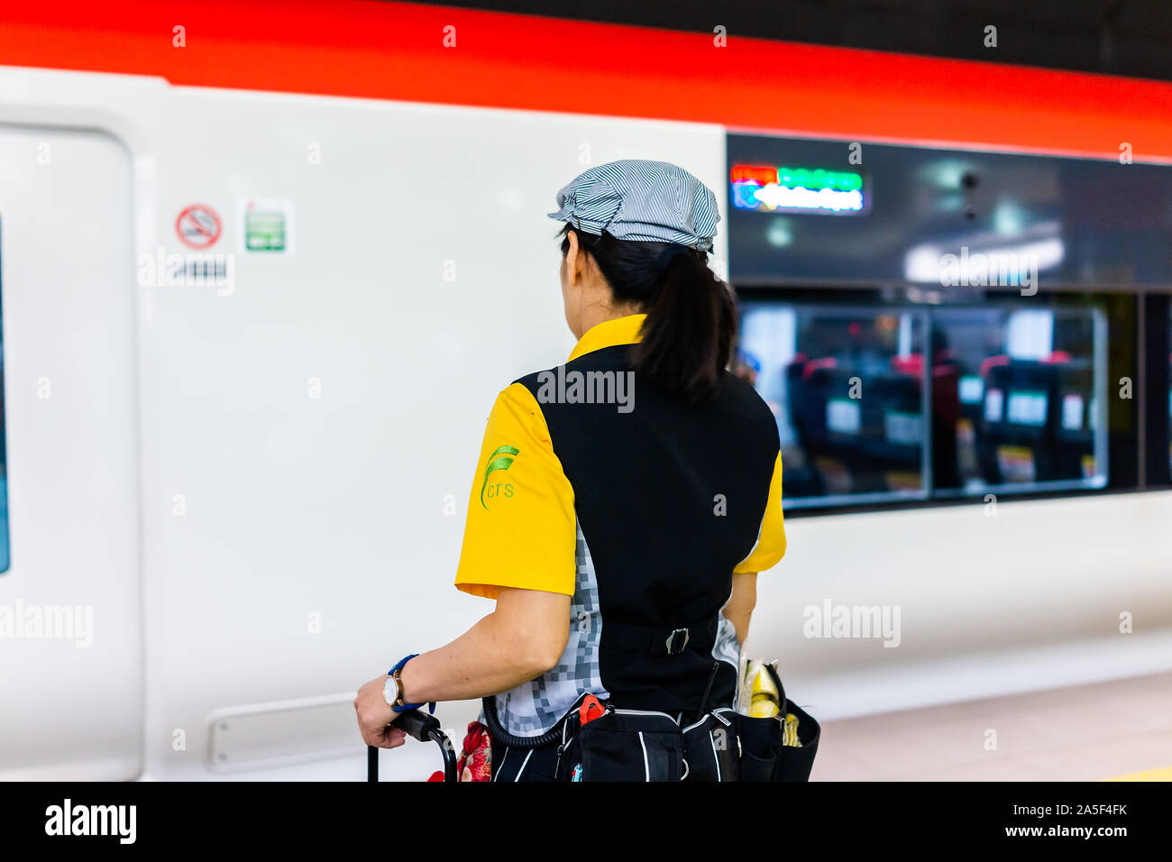 Narita, Japan - March 27, 2019: Woman Japanese worker cleaner waiting for express train at airport terminal station to clean the cabin holding equipme Stock Photo