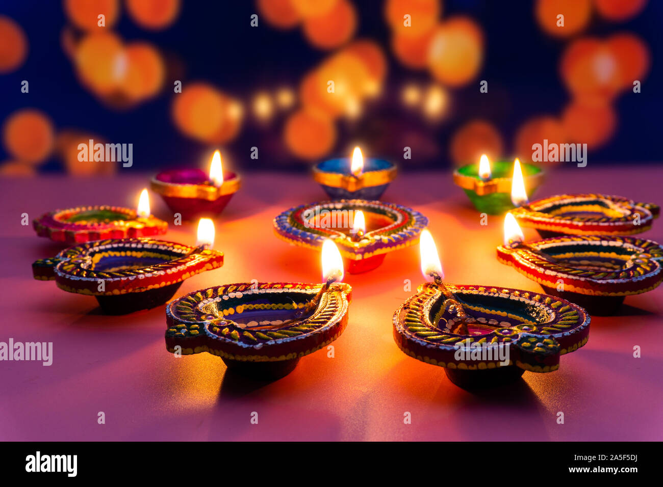 Indian festival Diwali, Diya oil lamps lit on colorful rangoli ...