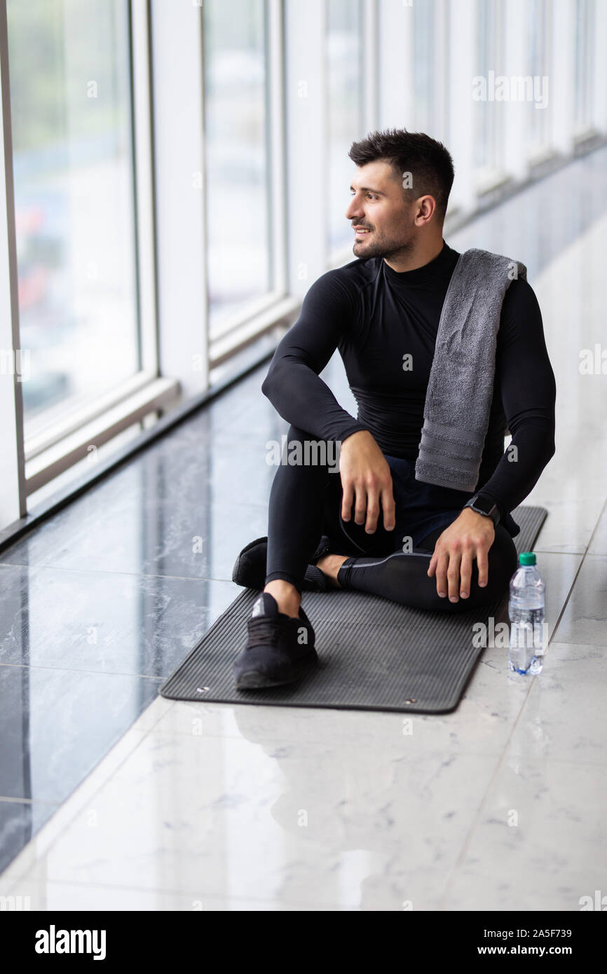 Sporty man resting, having break drinking water after doing exercise. Stock Photo
