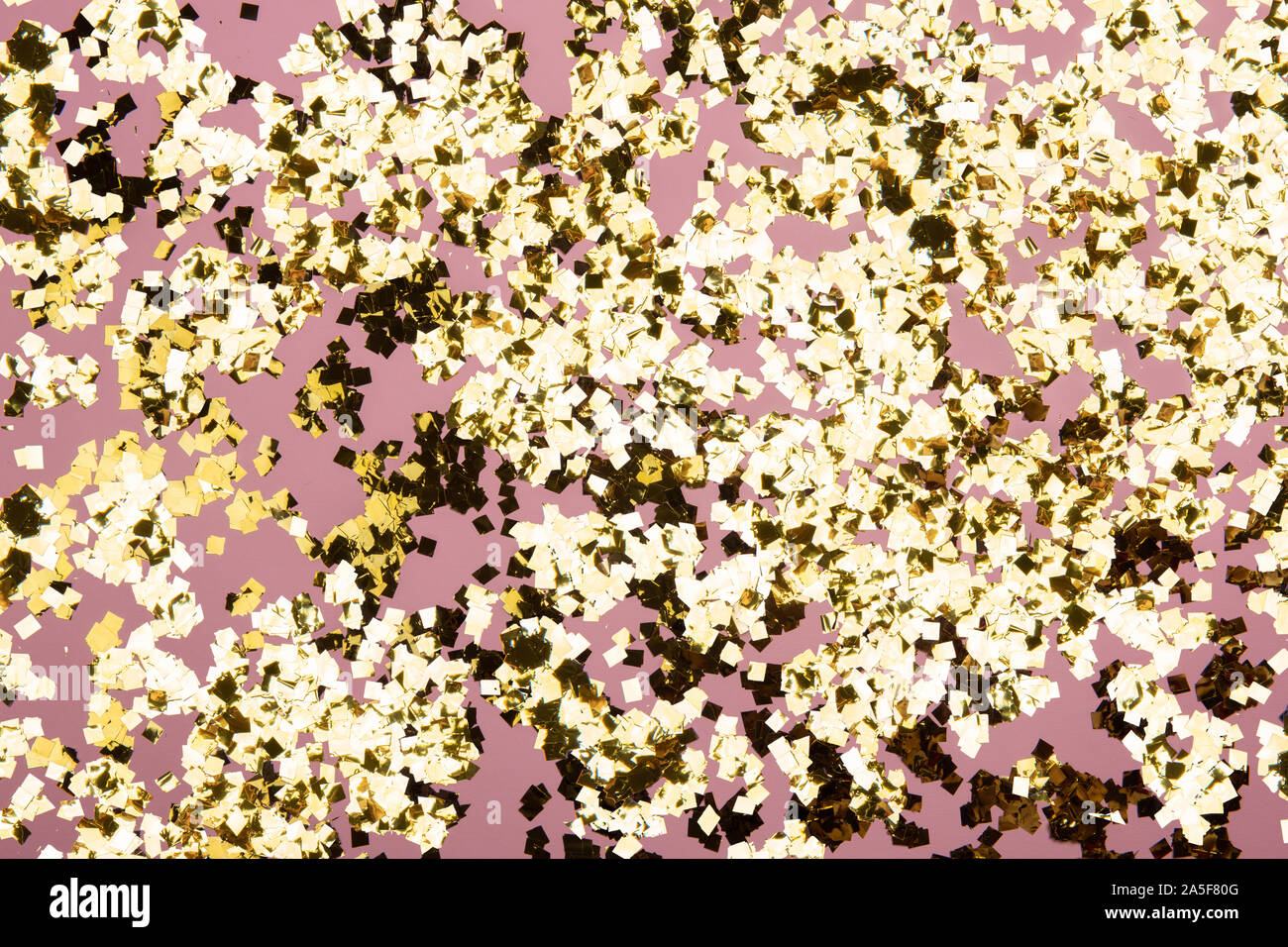 Golden confetti glitter on pink background. Festive holiday pastel ...
