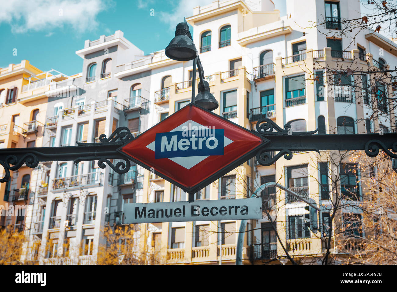Metro sign Madrid in foreground and unfocused buildings in the background. Autumn travel concept. Stock Photo