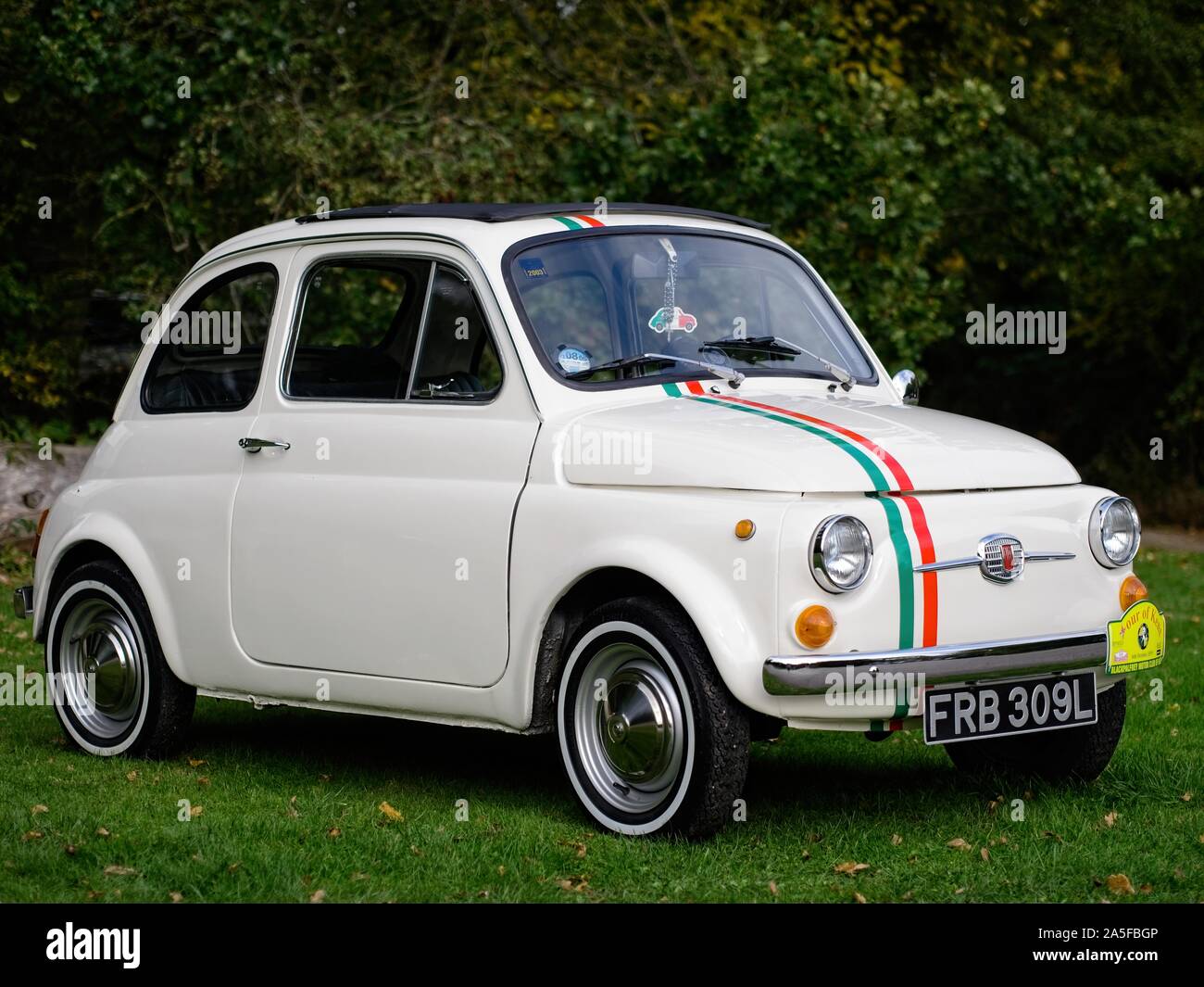 Fiat 500. A classic Fiat 500 Cinquecento parked on the green, it has Italian flag colours Stock Photo