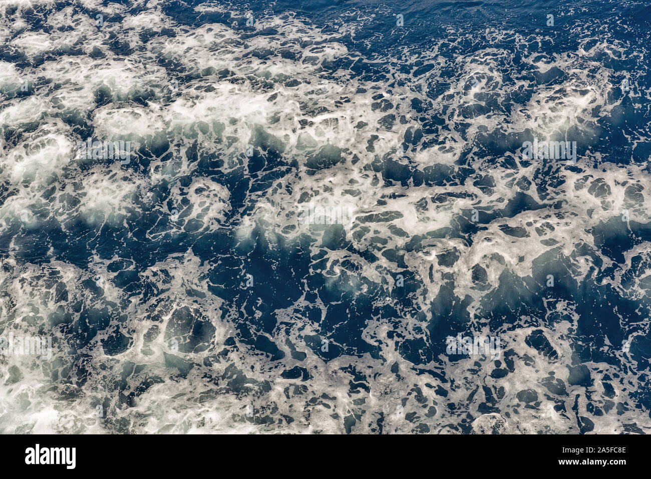 Seething surface of the deep sea with white foam background directly from above Stock Photo