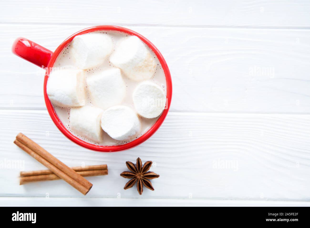 A red cup of homemade cacao or hot chocolade on white wooden table, space for text. Copy space. Top view. Stock Photo