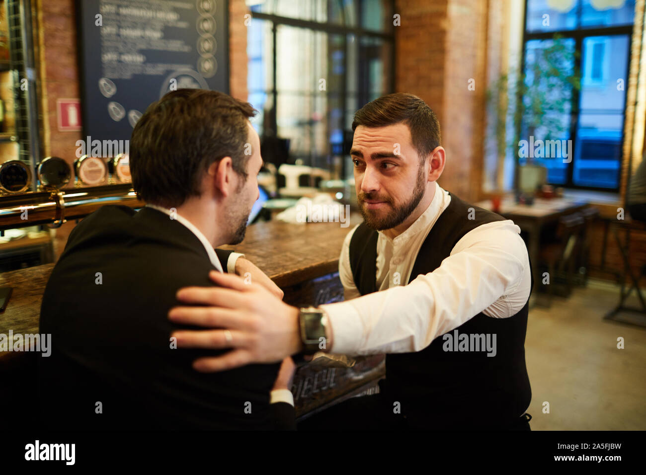 Portrait of two successful business people chatting sitting by bar after work and relaxing, copy space Stock Photo