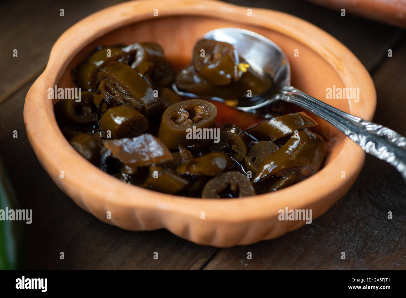 Pickled fire roasted peppers in clay dish Stock Photo Alamy