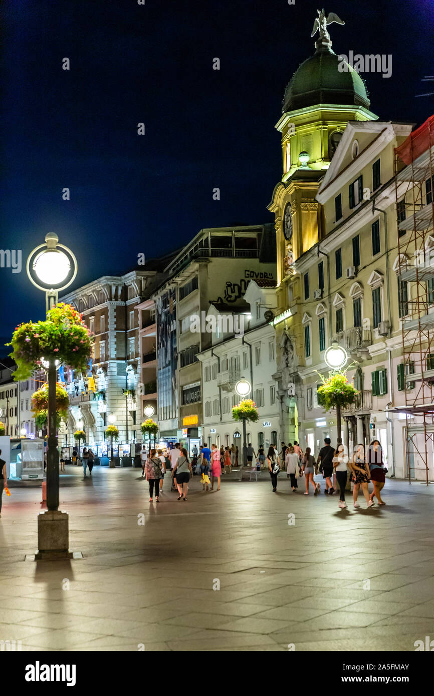 The Korzo pedestrian shopping zone and city clock tower in  the evening. Rijeka, Croatia, 2019 Stock Photo