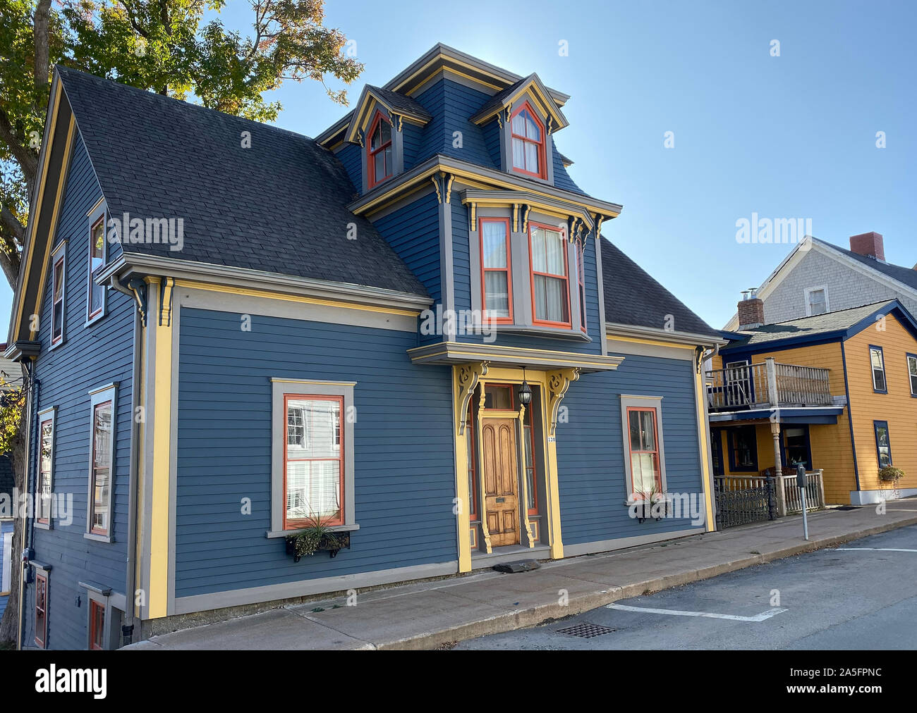 This photo of a house in the Nova Scotian town of Lunenburg dates to october 2019. Lunenburg is a port town on the South Shore of Nova Scotia, Canada. Founded in 1753, the town was one of the first British attempts to settle Protestants in Nova Scotia intended to displace Mi'kmaqs and Acadians. The architecture is unique: The mundane five-sided Scottish dormer is the central dormer and has, by hands of local craftsmen, been forever transformed into architectural legend, and it's only in Lunenburg. Lunenburg is a UNESCO World Heritage site. Stock Photo