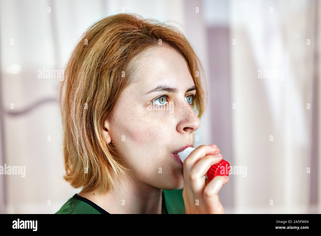 Beta-agonist therapy, use of an dry-powder inhaler with formoterol and budesonide in exacerbation of bronchial asthma. Woman is inhaling a bronchodila Stock Photo
