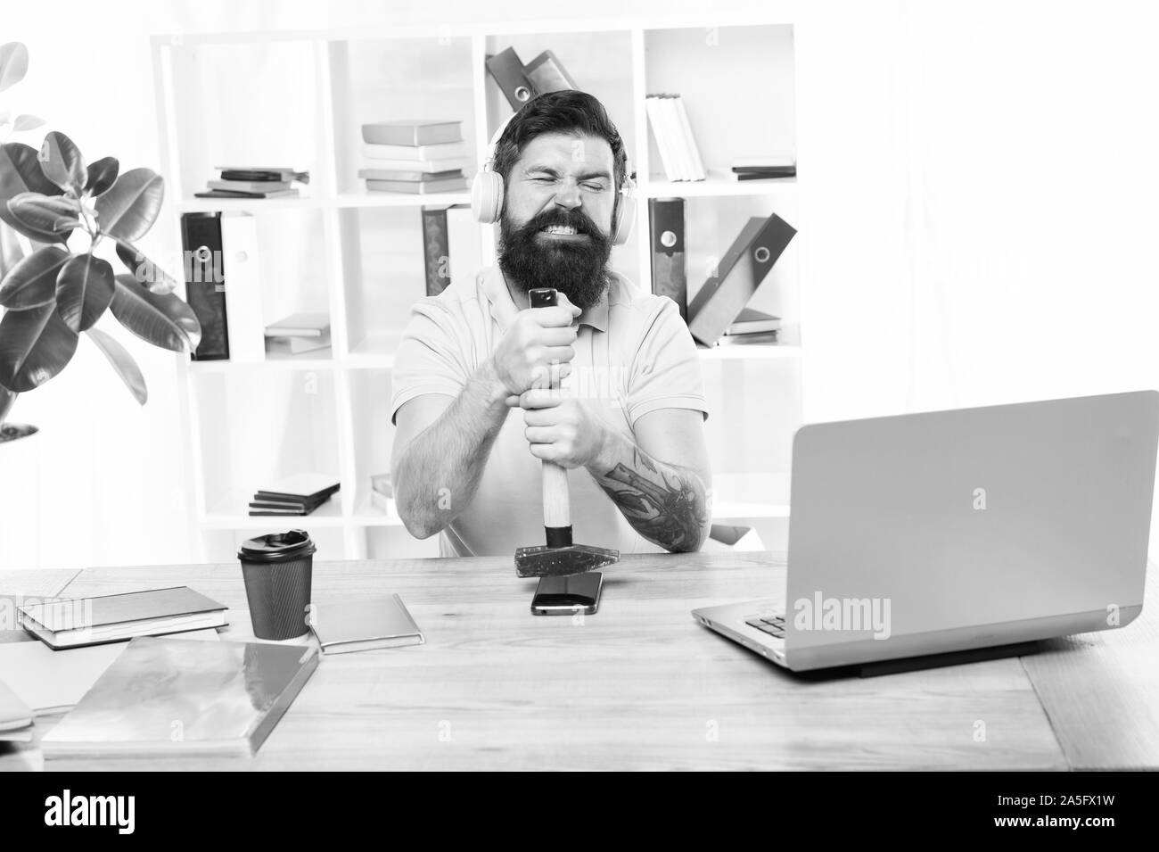 Spoiled communication. Failed mobile negotiations. Most annoying thing about work in call center. Incoming call. Stressful job at call center. Man bearded guy headphones office hammer smartphone. Stock Photo