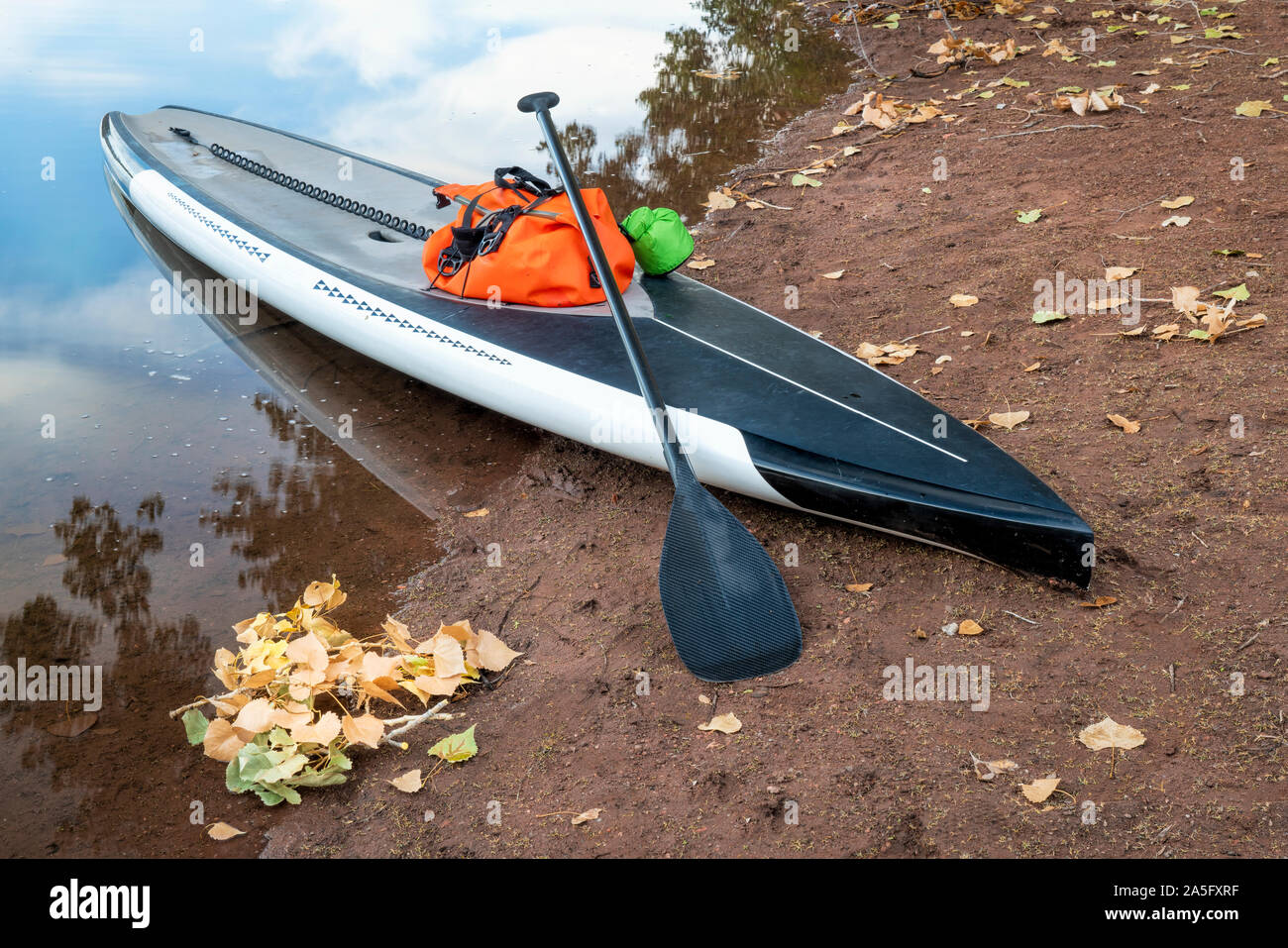touring stand up paddleboard with a paddle and dry bags on a lake beach Stock Photo Alamy