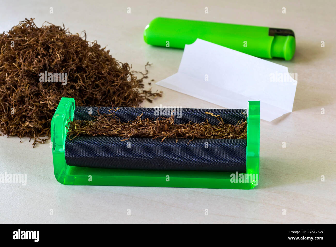 Green cigarette rolling machine, cigarette paper, green lighter and