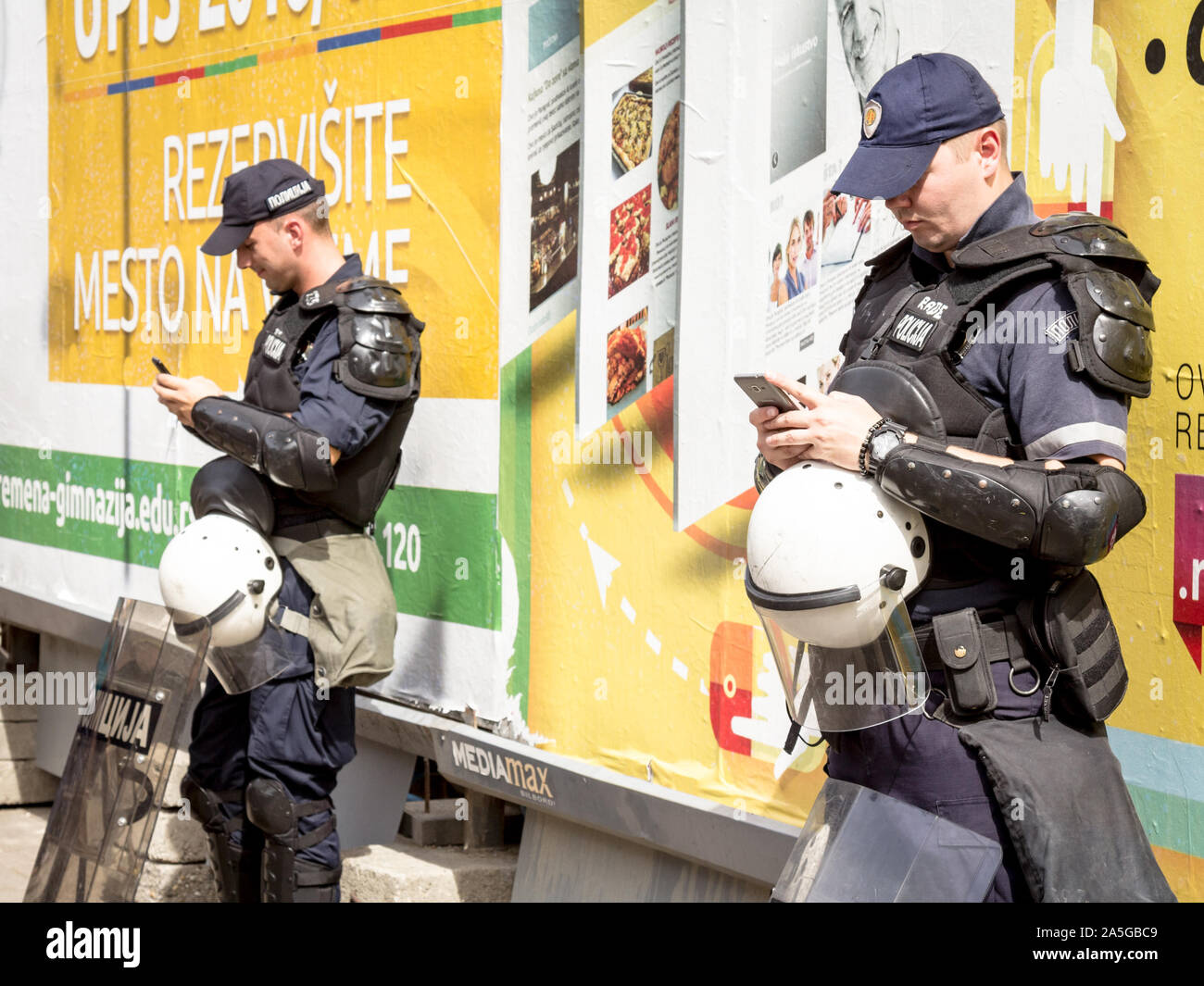 BELGRADE, SERBIA - SEPTEMBER 18, 2016: Serbian policemen looking at their smartphones while protecting the 2016 Belgrade Gay Pride wearing anti riot g Stock Photo