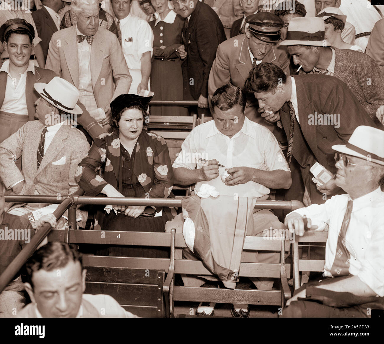 Babe Ruth - The Bambino -  still a favorite. Washington D.C. July 7. Although out of baseball for the last few years, 'Babe' Ruth still retains his popularity with the millions of baseball fans the country over. With Mrs. Ruth the 'Babe' is shown autographing a ball for an admirer at the All-Star game today at Griffith Stadium. 7/7/37 Stock Photo