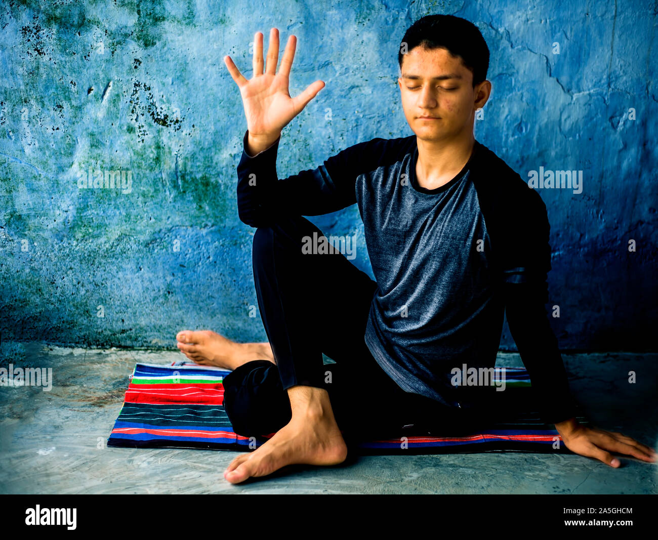 Half Lord of the Fishes Pose or Ardha Matsyendrasana performed by a  caucasian young man on the colorful mat by wearing black attire Stock Photo  - Alamy